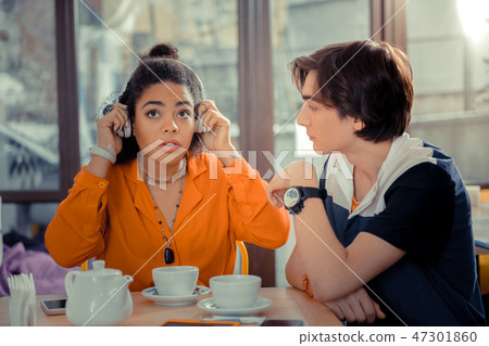 Girl is impressed by listening to the new music band 47301860