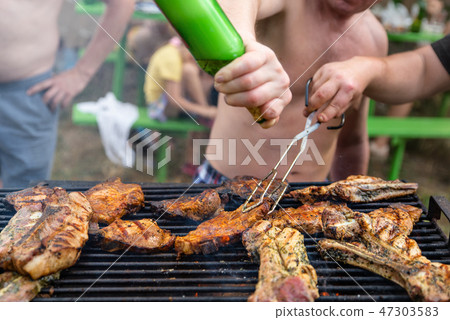 Friends frying the meat ribs and steaks Friends frying the meat ribs and steaks 47303583
