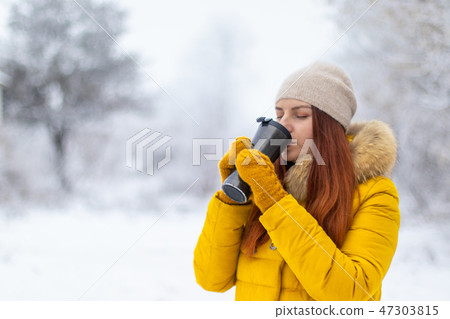 Young woman and is drinking coffee on the street  47303815