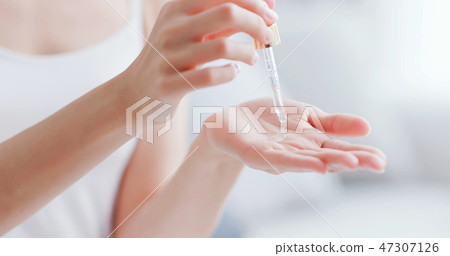 woman dropping moisturizer in hand woman dropping moisturizer in hand 47307126