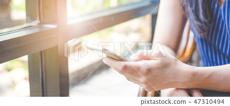 Close up of woman hand using a mobile phone Close up of woman hand using a mobile phone 47310494