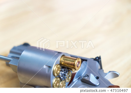 .44 magnum revolver gun with bullet on wood 47310497