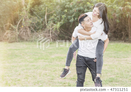 Boyfriend carrying his girlfriend on piggyback 47311251