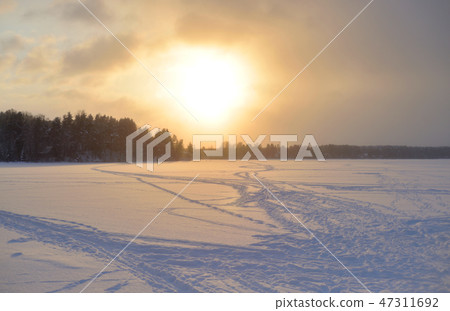 Frozen lake in the winter at sunset. Frozen lake in the winter at sunset. 47311692