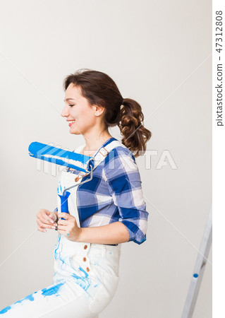 People, redecoration and renovation concept - Beautiful woman paints the wall in new apartment People, redecoration and renovation concept - Beautiful woman paints the wall in new apartment 47312808
