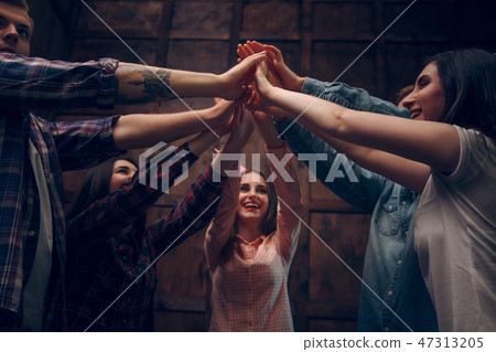 Happy friends join their hands in the air Happy friends join their hands in the air 47313205