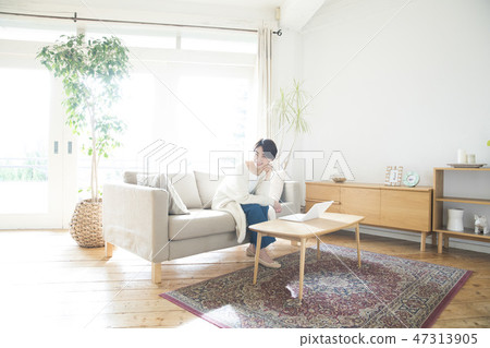 A woman who plays a personal computer in the living room 47313905