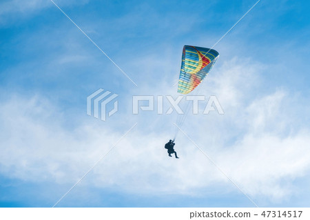 Paragliders in bright blue sky, tandem of instructor and beginner Paragliders in bright blue sky, tandem of instructor and beginner 47314517