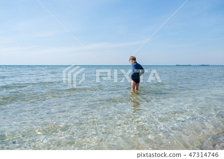 Cute boy on beach of sea 47314746