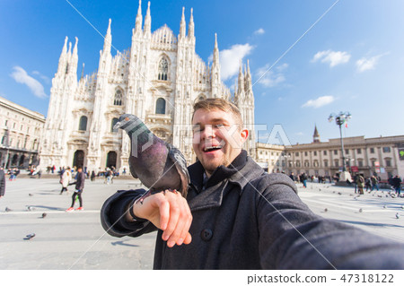 Travel, holidays and winter vacations concept - Happy man take selfie photo with funny pigeons in 47318122