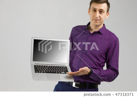 young man with laptop with an empty screen in his hands is isolated on light background 47318371