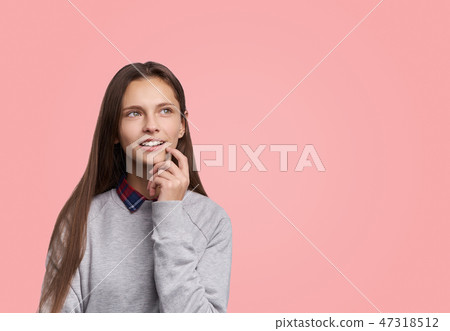 Pleased girl looks up with dreamful expression 47318512