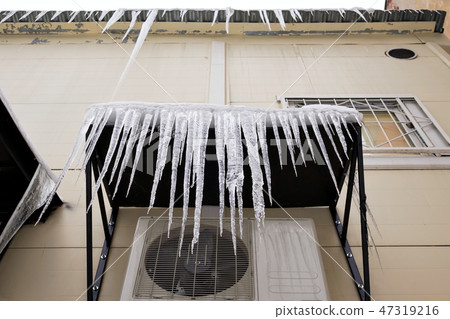 Long icicles fall from the roof on winter and early spring. Long icicles fall from the roof on winter and early spring. 47319216