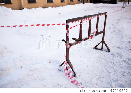 Fencing tape warns of the danger of icicles in winter time Fencing tape warns of the danger of icicles in winter time 47319232
