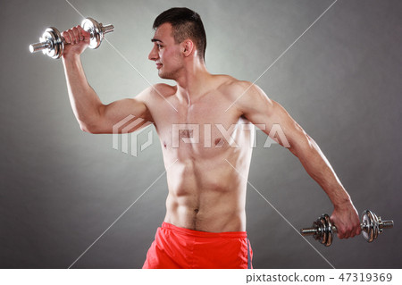 athletic man working with heavy dumbbells athletic man working with heavy dumbbells 47319369