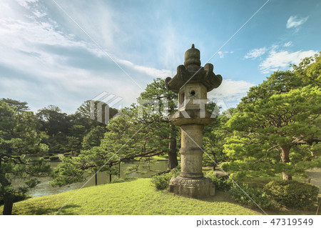 圍繞Ooizumi的一個巨大的石燈籠籃子在Rokugien在一個移民日本庭院裡在夏天藍天的Hon Komagome，杉樹。 47319549