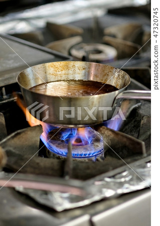 Preparation of soup in silver pan on gas. 47320745