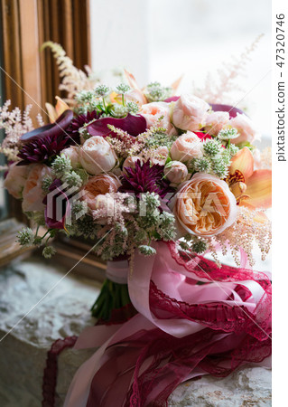 peach dark red wedding bouquet stands on the windowsill peach dark red wedding bouquet stands on the windowsill 47320746