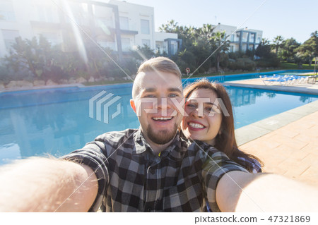 Travel, vacation and holiday concept - Beautiful love couple having fun taking selfie near a 47321869