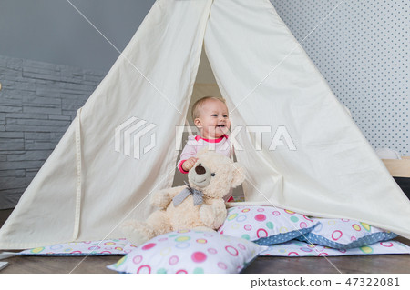 Child playing with a teepee tent Child playing with a teepee tent 47322081