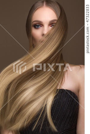 Beautiful blond girl with a perfectly smooth hair, classic make-up. Beauty face 47322833
