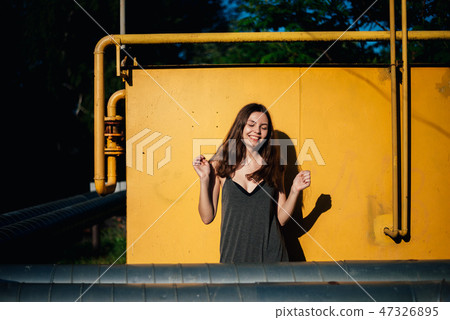 Girl dancing in front of a yellow wall 47326895