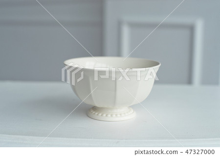 Elegant saucer on white table in large bright room. Elegant saucer on white table in large bright room. 47327000