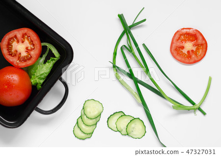 Scallions in center on a black oven dish healthy ingredient raw food concept Scallions in center on a black oven dish healthy ingredient raw food concept 47327031
