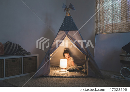 Girl playing in the teepee Girl playing in the teepee 47328296