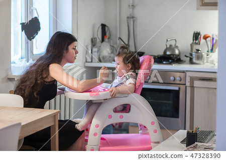 Young mother feeding daughter Young mother feeding daughter 47328390
