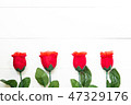 Present gift with red rose flower on wooden table 47329176