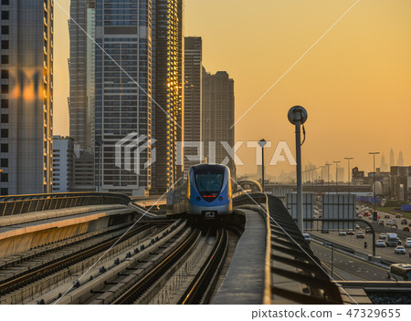 A metro train running on track at sunset 47329655