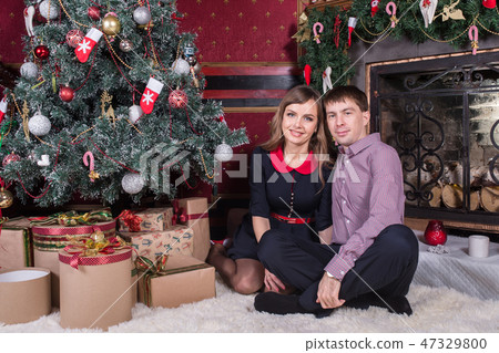 Happy young people near the Christmas tree. 47329800