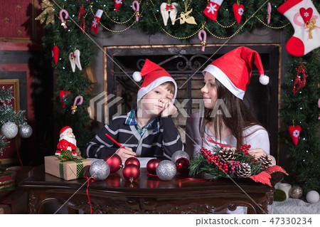 mother and son writing letter to Santa 47330234