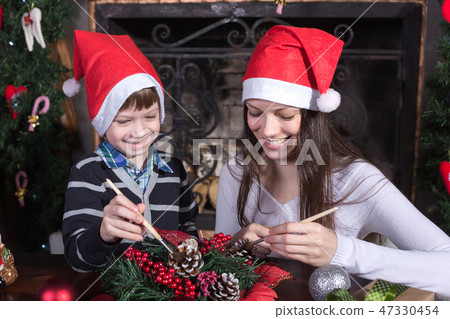 Happy baby helping mother decorate Happy baby helping mother decorate 47330454