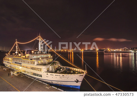 Night view of the NYK Hikawa Maru with a cruise on the royal wing moored in the dock at Yamashita Park in Yokohama and the background. 47330573