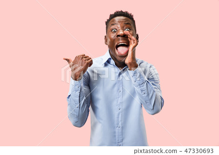 The young man whispering a secret behind her hand over pink background 47330693