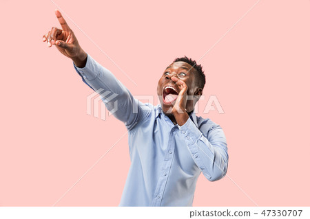 Isolated on pink young casual man shouting at studio 47330707