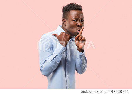 The young man whispering a secret behind her hand over pink background The young man whispering a secret behind her hand over pink background 47330765