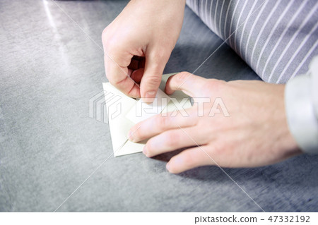 Close up of male hands that hiding paper into envelope 47332192