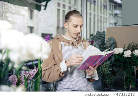 Serious gardener reading article about modern plants Serious gardener reading article about modern plants 47332218