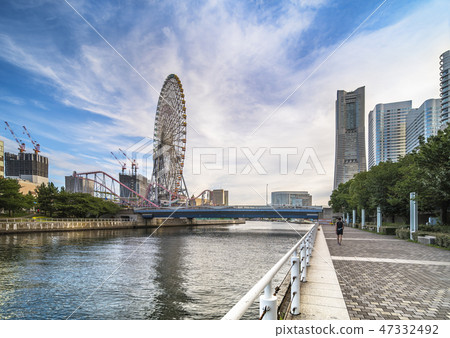Running at Cosmo Clock 21 and Landmark Tower, a large Ferris wheel of Cosmo Wall amusement park in Minato Mirai in Yokohama Running at Cosmo Clock 21 and Landmark Tower, a large Ferris wheel of Cosmo Wall amusement park in Minato Mirai in Yokohama 47332492