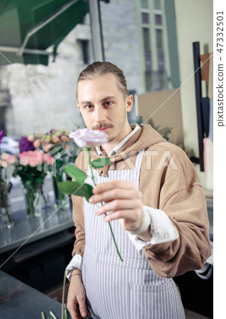 Cheerful young male person demonstrating new art of rose Cheerful young male person demonstrating new art of rose 47332501