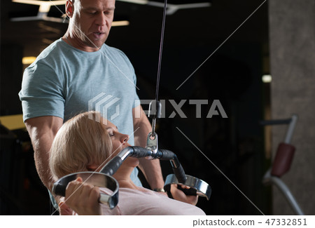 Strong male professional trainer helps his client 47332851