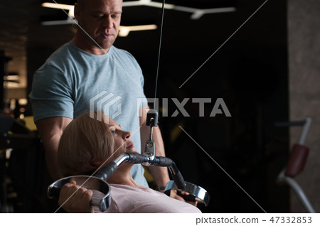 Strong male professional trainer helps his client 47332853