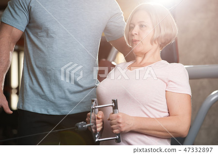 A male trainer helps his female client A male trainer helps his female client 47332897