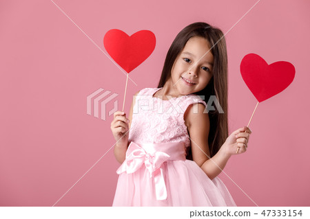 cute little girl in a pink dress holding a paper heart cute little girl in a pink dress holding a paper heart 47333154