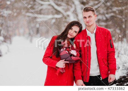 A date of lovers with my park in the winter. A bouquet of red flowers, walk, hug, kiss, laugh in a A date of lovers with my park in the winter. A bouquet of red flowers, walk, hug, kiss, laugh in a 47333862