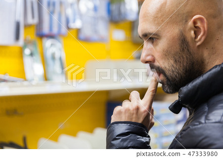 young man purchasing a hand tool in hardware shop 47333980