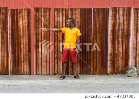 Young happy black African man smiling and pointing to the side w 47334303